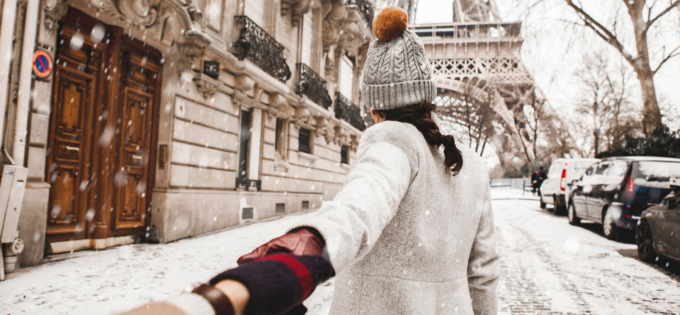 Image: Woman walking to the Eiffel Tower in the snow, Paris, France. (photo via iStock/Getty Images E+/Orbon Alija)