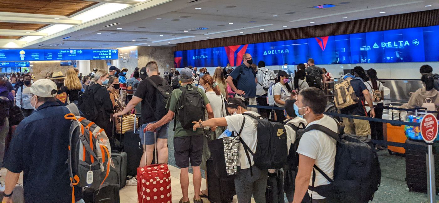 Image: Travelers wait in line to check-in at the airport. (photo by Eric Bowman)