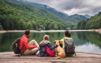 Family with dog resting on a pier (Photo iva  Kerkez / iStock / Getty Images Plus)