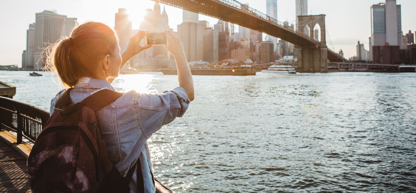 Image: Traveler in New York City taking a picture (Photo Credit: Getty/ svetikd)