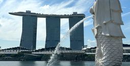 Merlion statue with casino hotel and bay in background