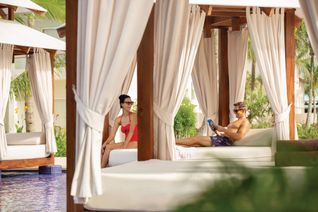 A couple sits at a cabana in the adults-only infinity pool at the Hilton La Romana Adults-Only Resort.
