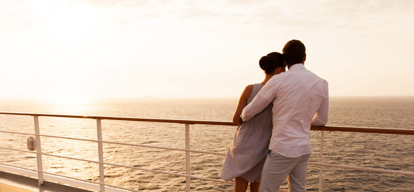 Photo: Couple hugging at sunset on cruise ship. (photo via michaeljung / iStock / Getty Images Plus)