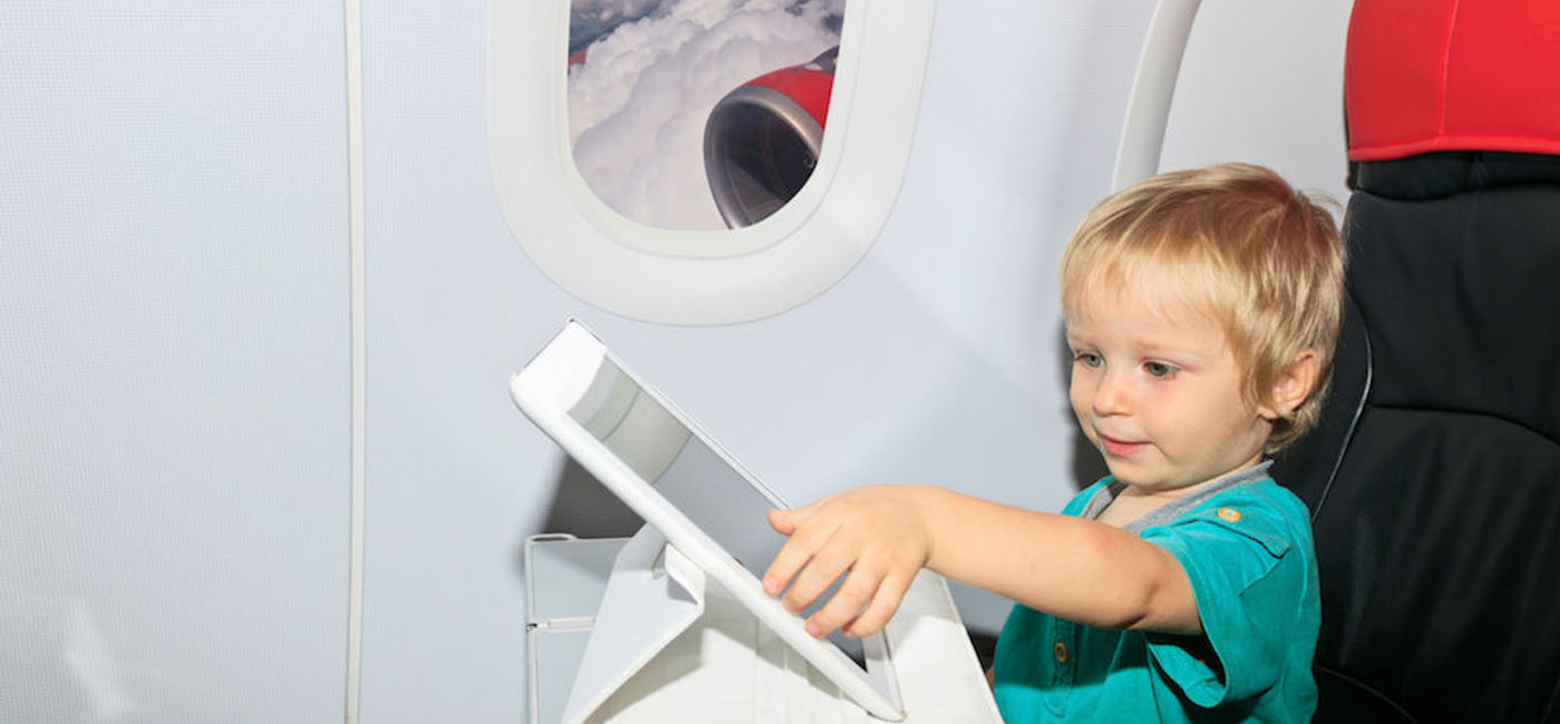 Image: PHOTO: Little boy on plane playing with electronic device. (photo courtesy of Thinkstock) 
