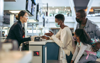Family at airport check-in desk.