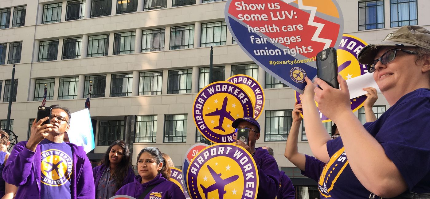 Image: Airport workers hold signs calling on Southwest to "Show us some LUV." (photo via SEIU)