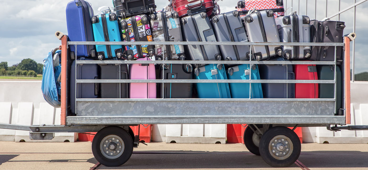 Image: A trailer filled with checked baggage at the airport.  (Source: iStock/Getty Images Plus/Ben-Schonewille)