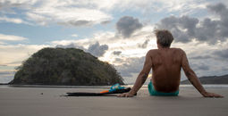 Man with snorkeling equipment relaxes on beach in Panama in the morning 