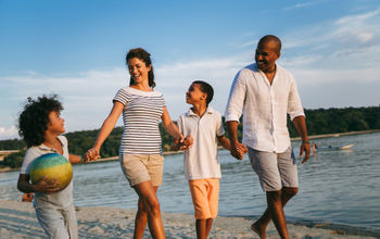 family holding hands walking on the beach