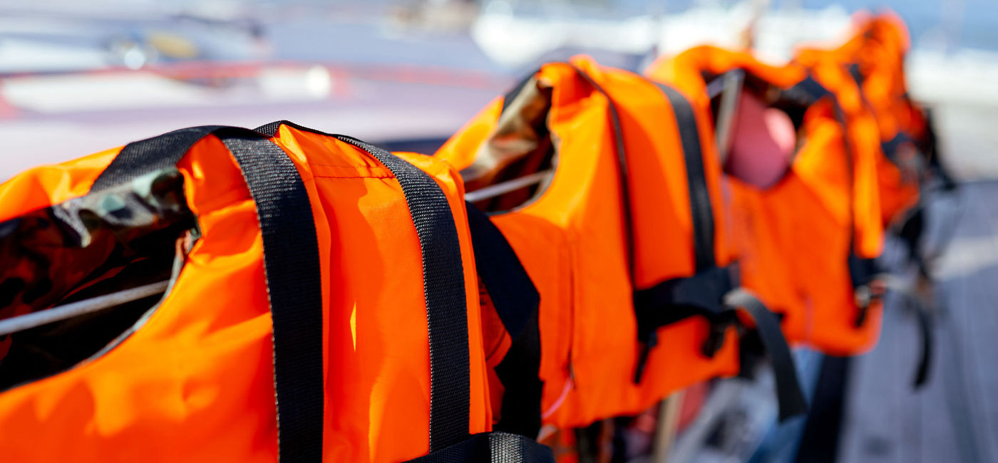 Image: Life jackets laid out on a railing. (photo via iStock/Getty Images Plus/Anton Ilchanka)