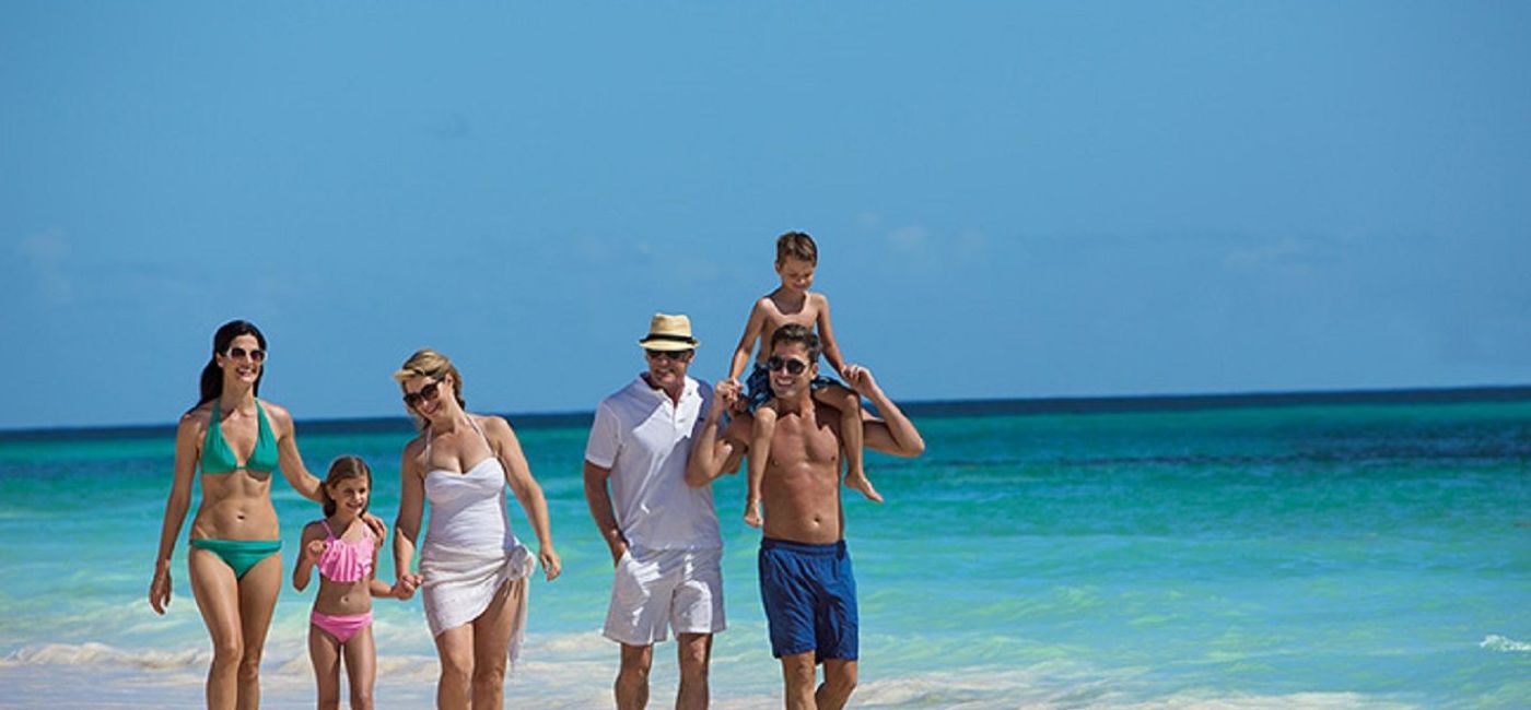 Image: A family on the beach at Now Resorts & Spas. (photo via AMResorts)