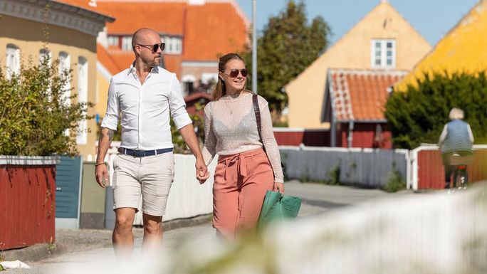 A couple strolls through the town of Skagen.