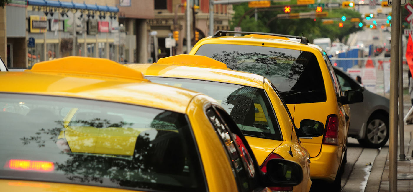 Image: A row of taxis waiting to pick up passengers in Canada. (photo via iStock/Getty Images Plus/erlucho)