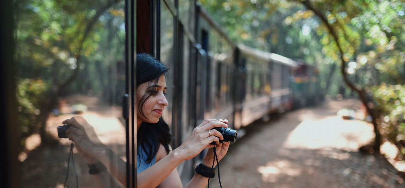 Image: Traveler takes photos out of a train window. (photo via Booking.com) ((photo via Booking.com))