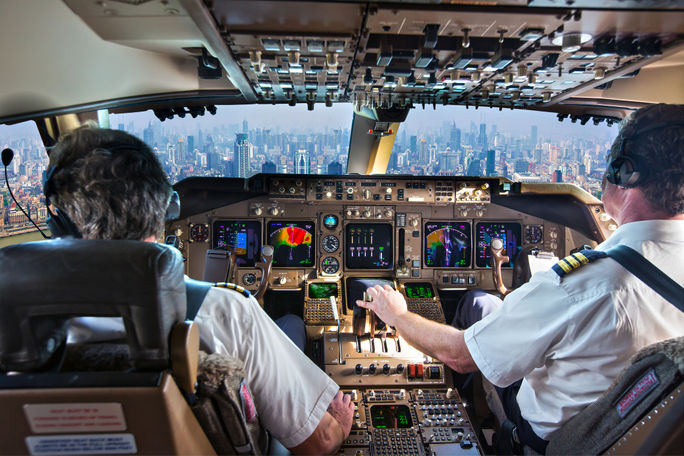 Commercial passenger aircraft pilots in the cockpit.