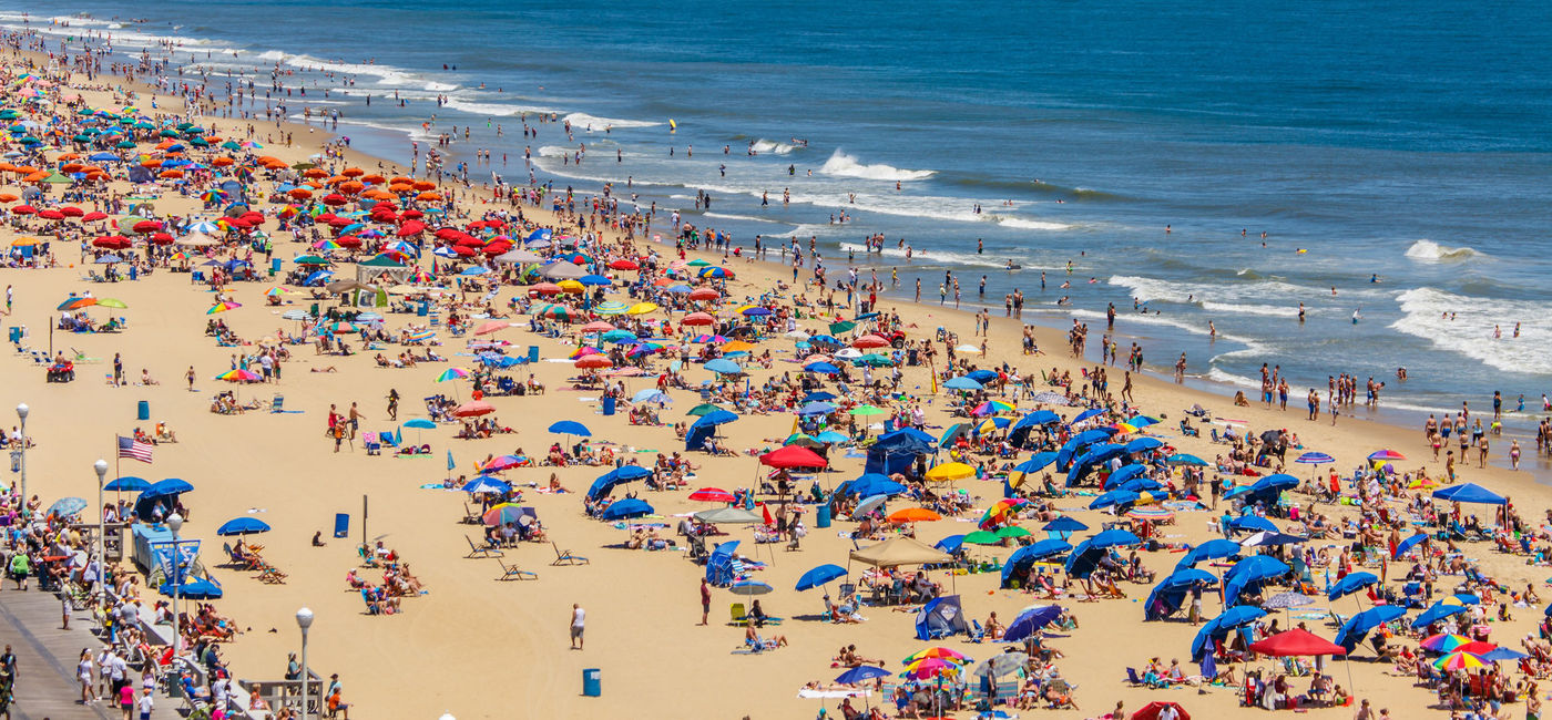 Image: A crowded U.S. beach filled with people and umbrellas. (photo via iStock/Getty Images Plus/rypson)