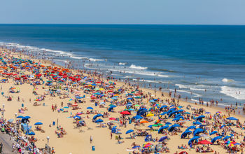 A crowded U.S. beach filled with people and umbrellas.