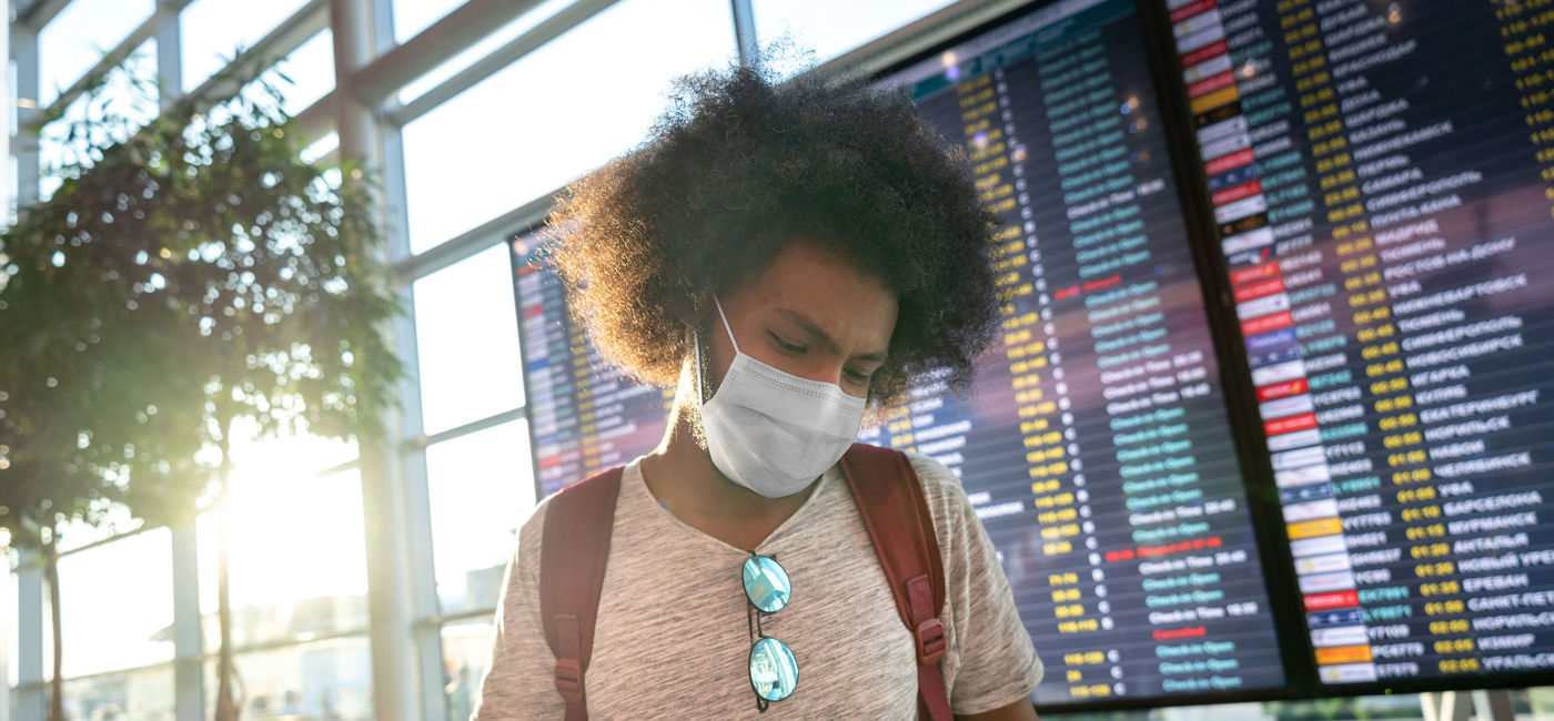 Image: Male traveler wearing a facemask at the airport. (photo via andresr / E+)