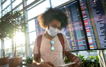 Male traveler wearing a facemask at the airport.