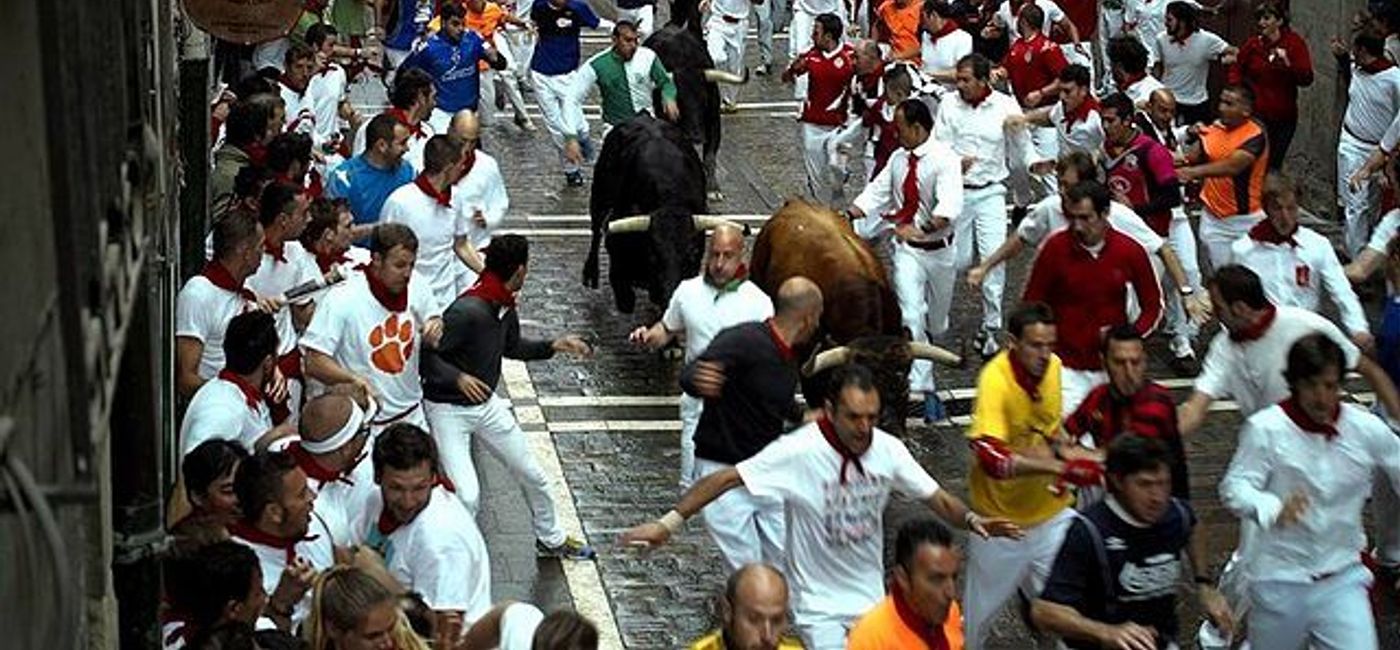 Image: PHOTO: A Pamplona bull run in full swing. (photo via Wikimedia Commons/Btodag)