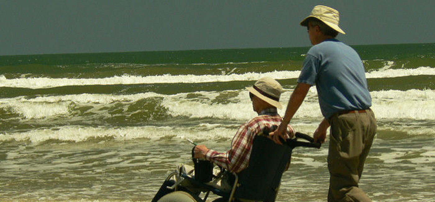 Image: PHOTO: A caregiver and his “caree” on the beach. (Photo via Flickr/Terry Ross) 