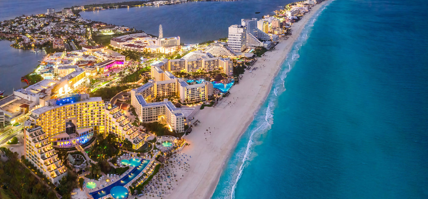 Image: Cancun's Hotel Zone at sunset, Quintana Roo, Mexico. (photo via Jonathan Ross / iStock / Getty Images Plus)
