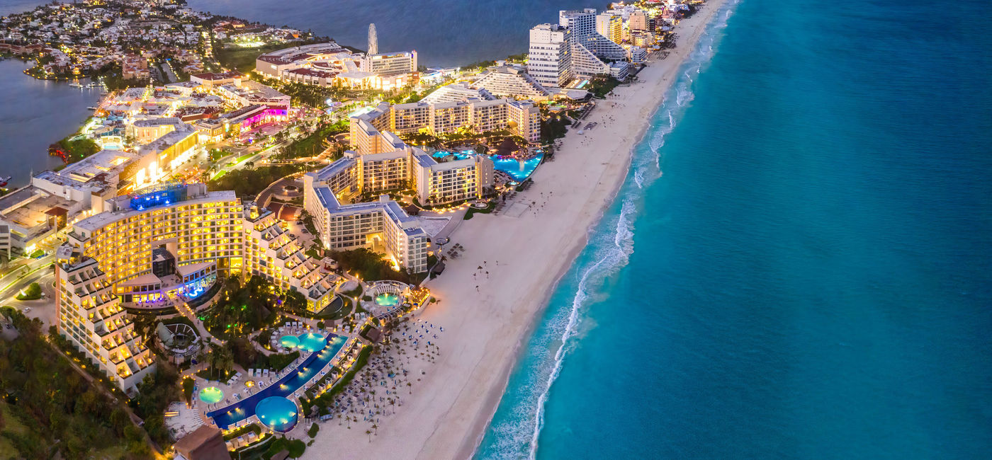 Image: Cancun beach coast at sunset, Quintana Roo, Mexico. (photo via Jonathan Ross / iStock / Getty Images Plus)