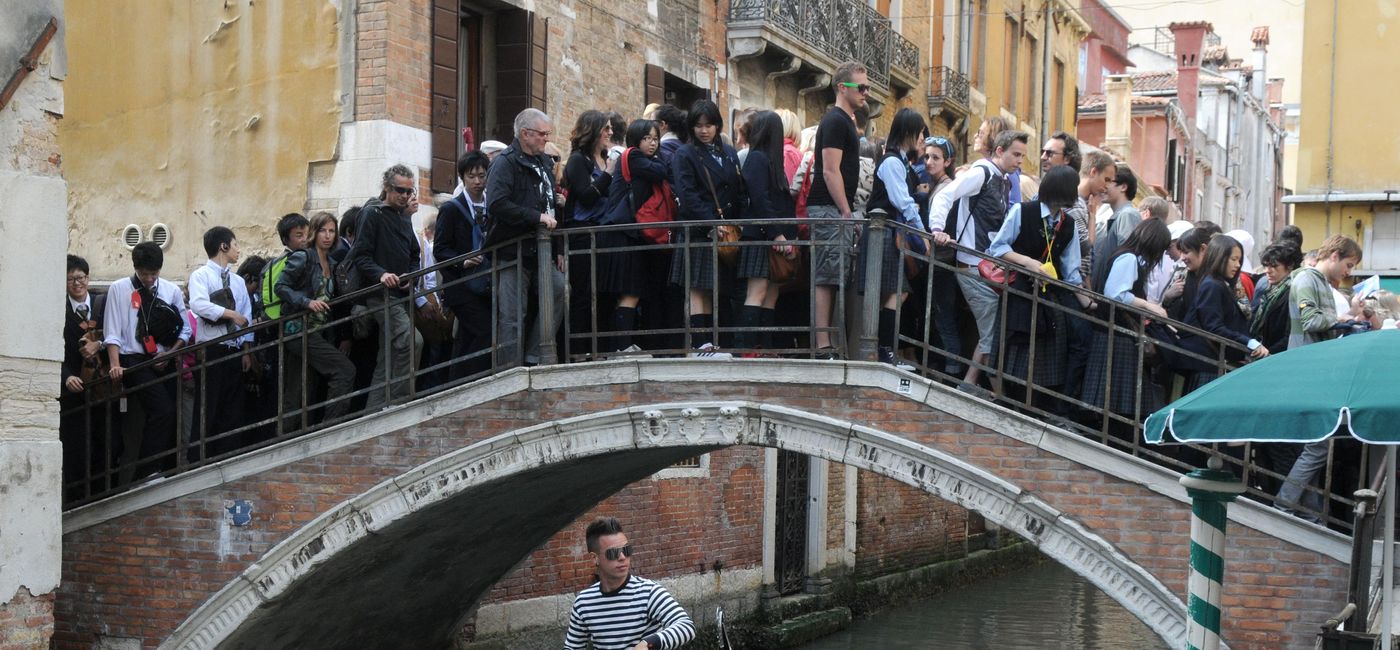 Image: Tourists on a crowded bridge in Venice, Italy.  (photo via Bumblee_Dee / iStock Editorial / Getty Images Plus)