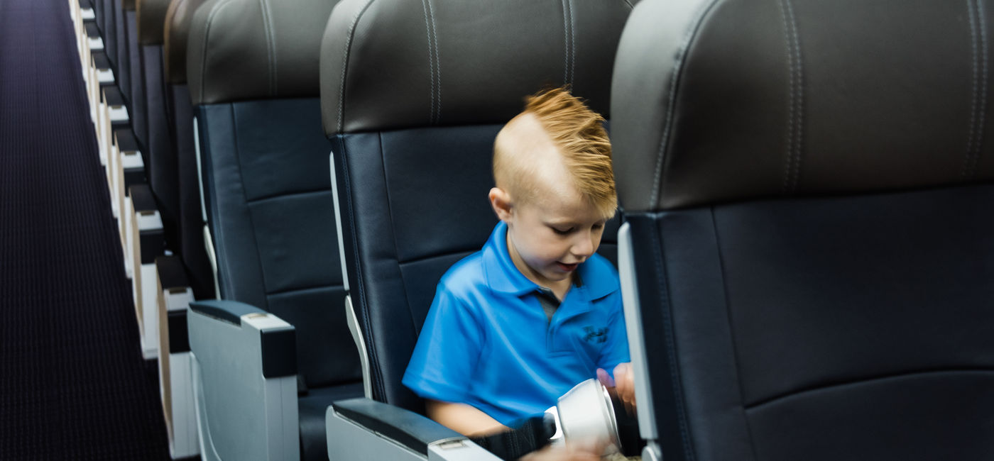 Image: Young Presley Rudge, the inspiration behind the airport's new project, tests out the new sensory-friendly cabin. (photo via American Airlines)