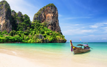 Traditional wooden longtail boat moored on a beach in Thailand.