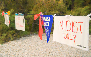 Nudists only sign.