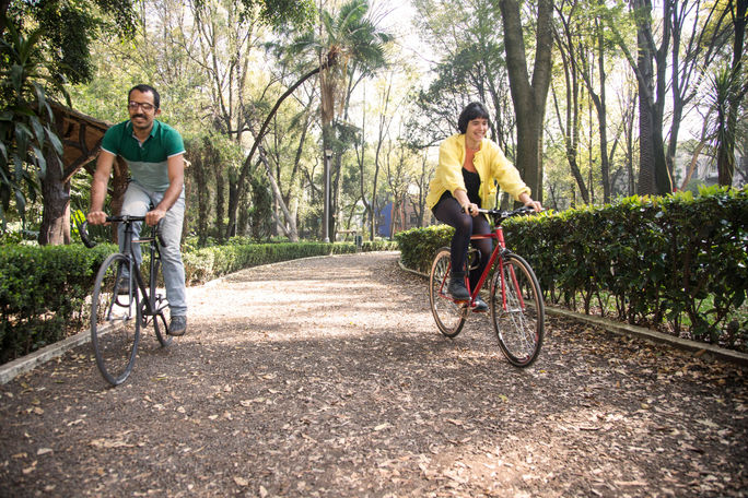 Friends cycling through a park in Mexico City