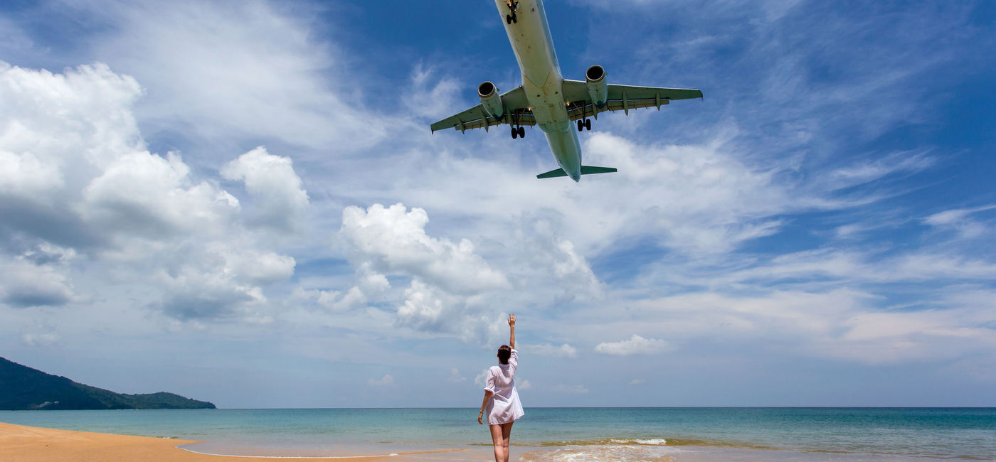 Image: Plane landing at Phuket Airport over a beach. (photo via  iStock / Getty Images Plus /  southtownboy)