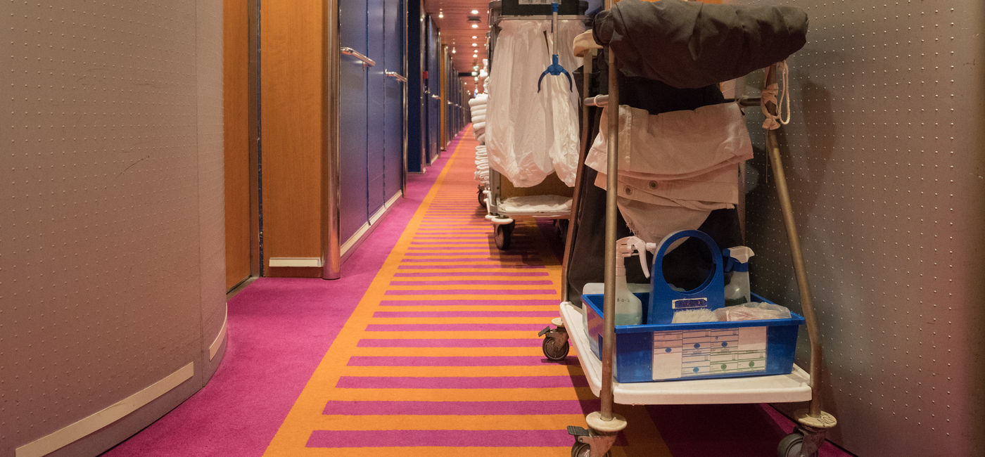 Image: Cleaning carts in corridor on a cruise ship. (photo via mgstudyo / iStock / Getty Images Plus)
