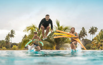 Tourists bathing in resort swimming pool.
