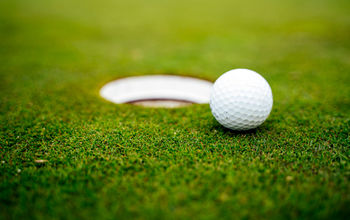 golf ball on edge of hole