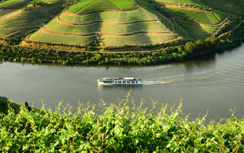 The Scenic Azure sails past vineyards on the Douro River in Portugal