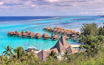Overview of hotel with overwater bungalows on turquoise lagoon