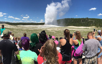 Crowd of visitors watching 'Old Faithful' geyser erupt in Yellowstone National Park, Wyoming.
