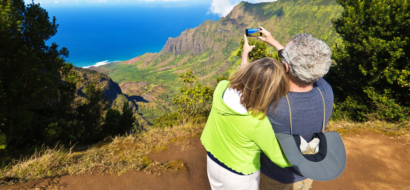 Image: PHOTO: Tourist couple at Waimea Canyon State Park, Kauai, Hawaii. (photo via YinYang/E+)