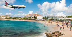 Delta flight approaches St Maarten's Princess Juliana Airport above onlookers on Maho Beach