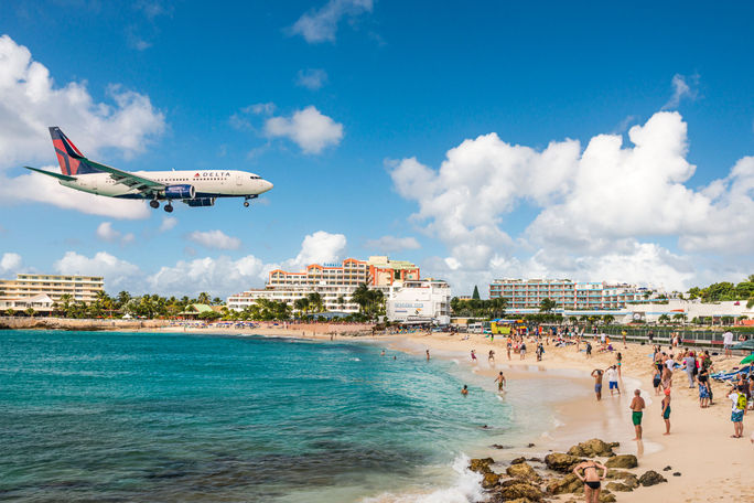 Delta flight approaches St Maarten's Princess Juliana Airport above onlookers on Maho Beach Delta flight approaches St Maarten's Princess Juliana Airport above onlookers on Maho Beach