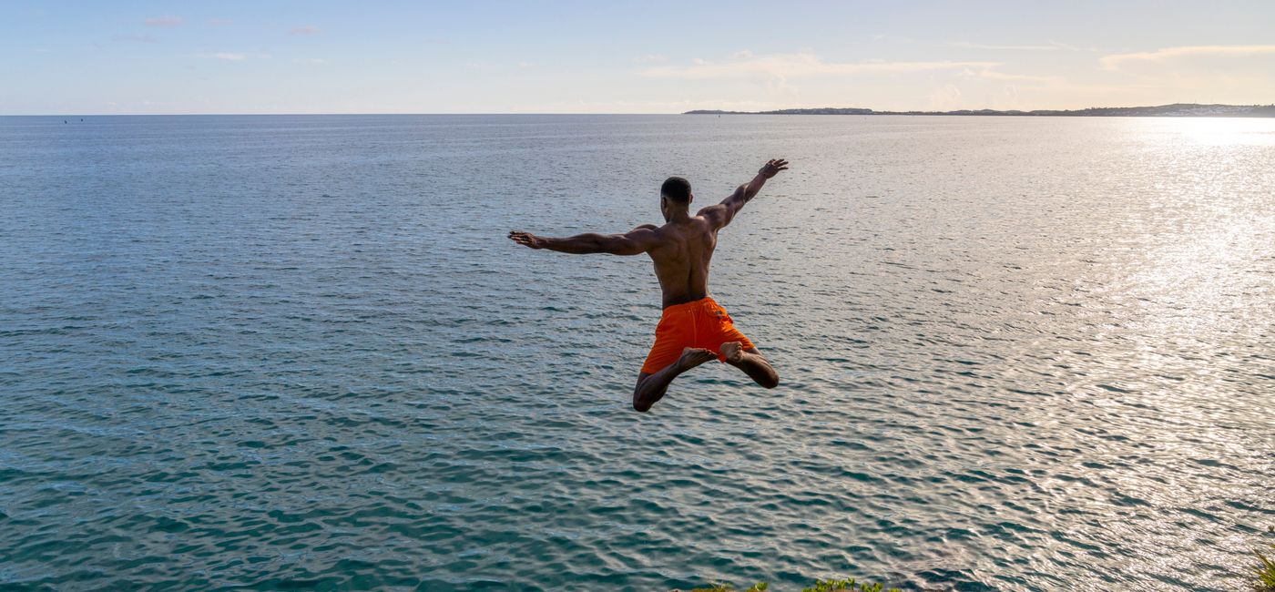 Image: A man jumps off a cliff into the sea in Bermuda. (photo via Bermuda Tourism Authority) (Photo Credit: (photo via Bermuda Tourism Authority))