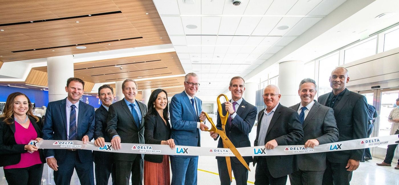 Image: Delta Air Lines CEO Ed Baastian, left with scissors, helps christen the first phase of the Delta Sky Way project at Los Angeles International Airport. (photo via Delta Air Lines)