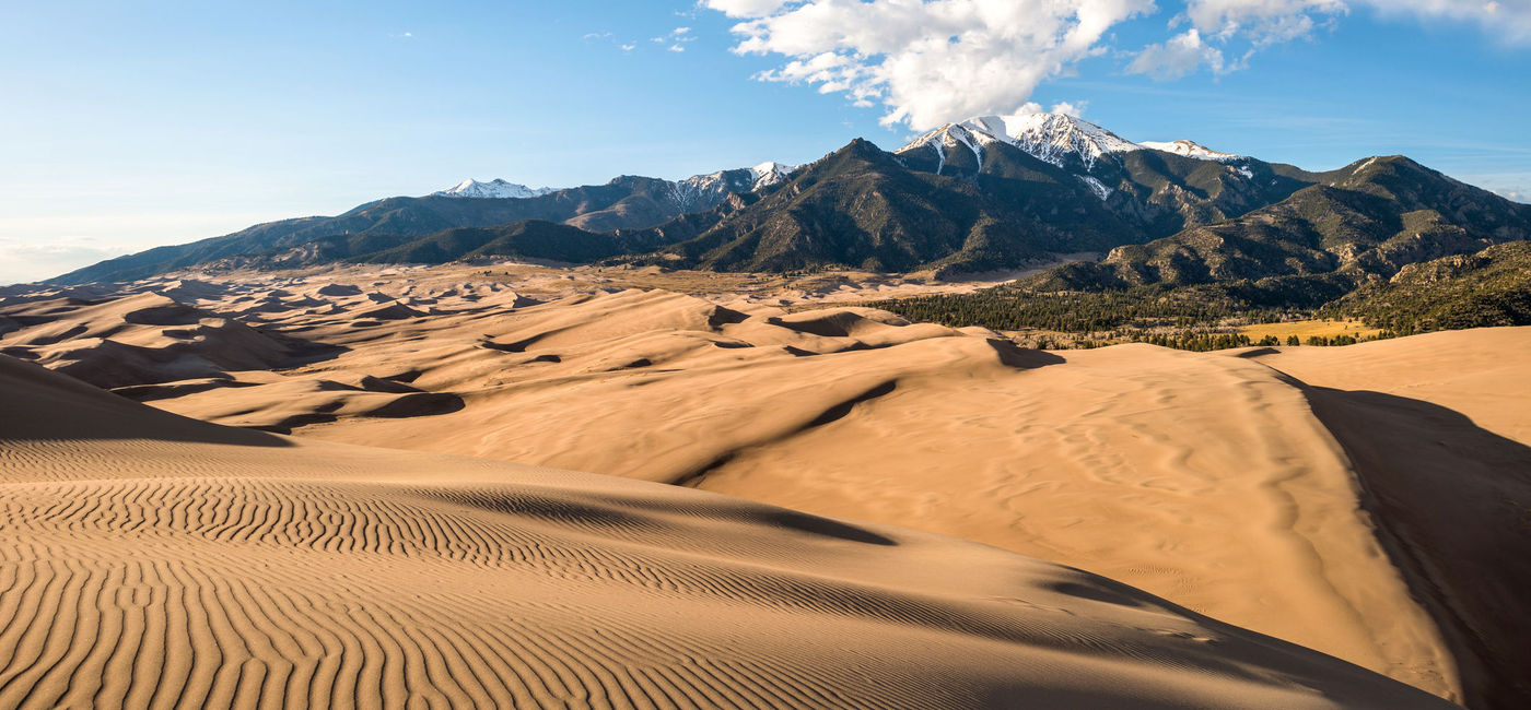 Image: Sunset view of sand waves at the top of Great Sand Dunes National Park & Preserve, Colorado. (photo via SeanXu/iStock/Getty Images Plus)