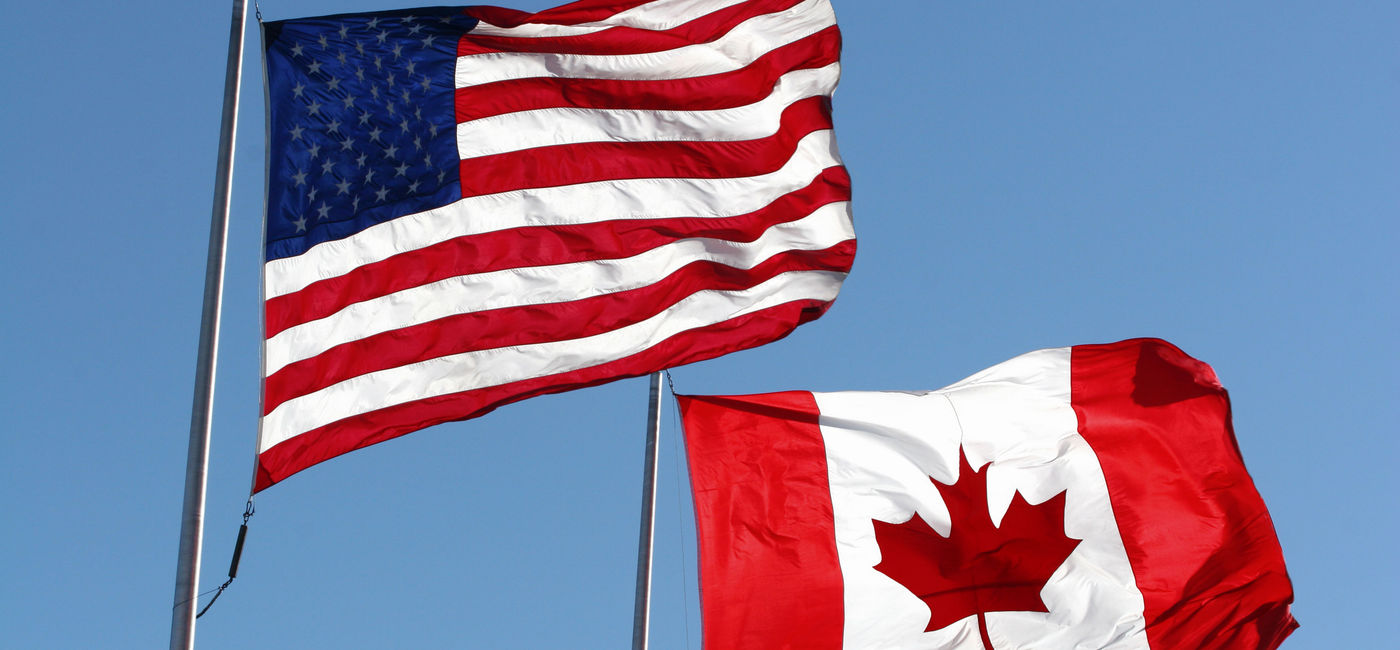 Image: The U.S. and Canadian national flags. (Photo via iStock/Getty Images E+/KKIDD)