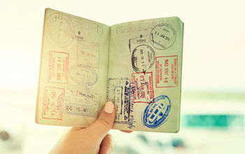 Person holding a passport filled with stamps.