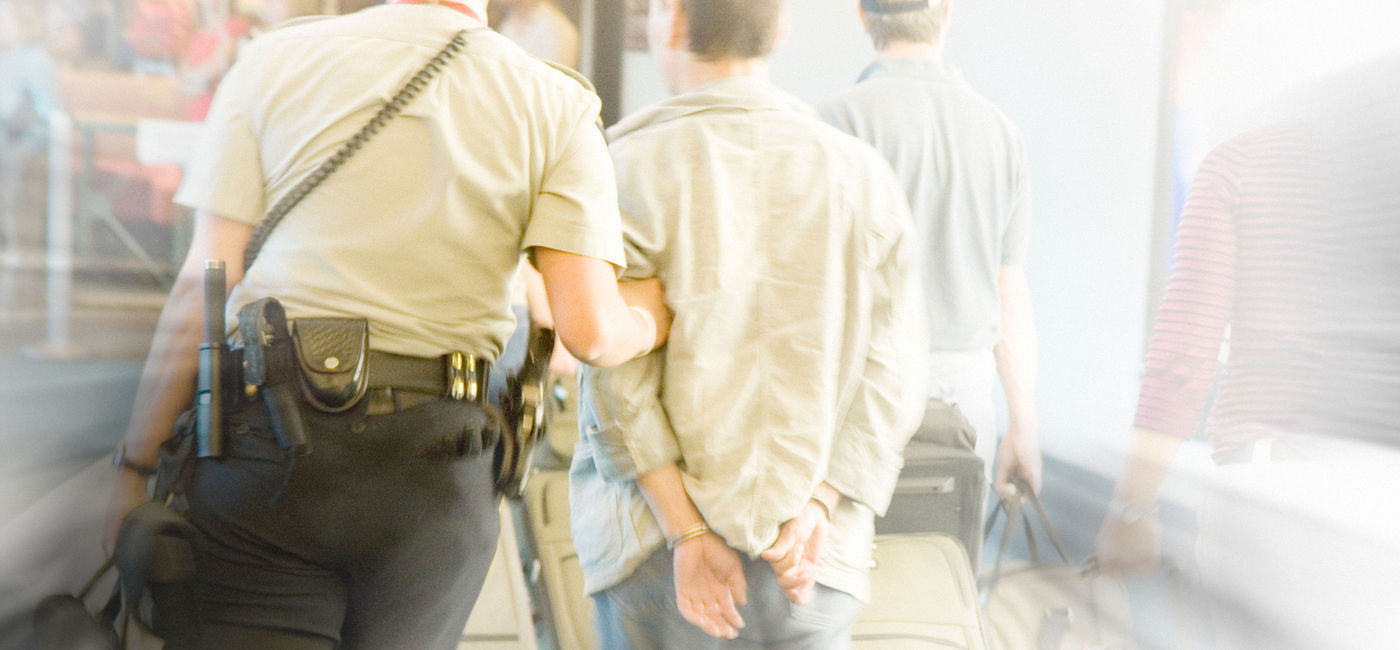 Image: PHOTO: Airport security escorting a man off of an airplane. (photo via ranplett/E+)