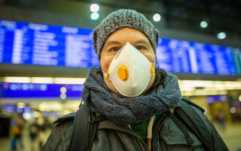 Man wearing a mask at a train station