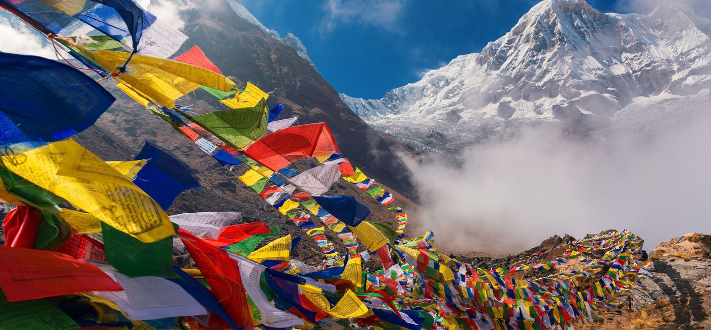 Image: Prayer flags and Mount Annapurna, Nepal. (photo via iStock/Getty Images Plus/Devilkae)